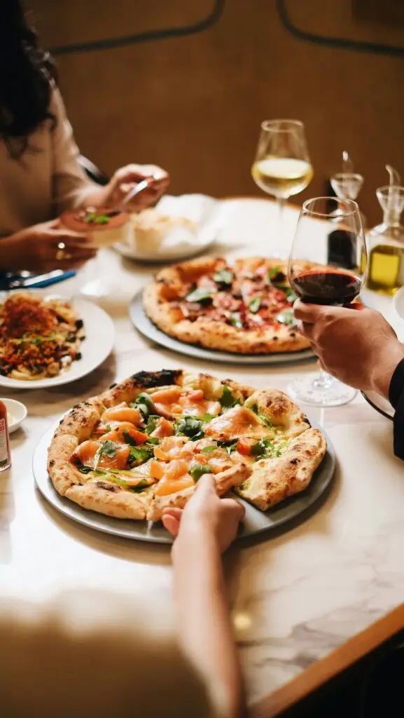 client en train de manger des pizza et de boire du vins